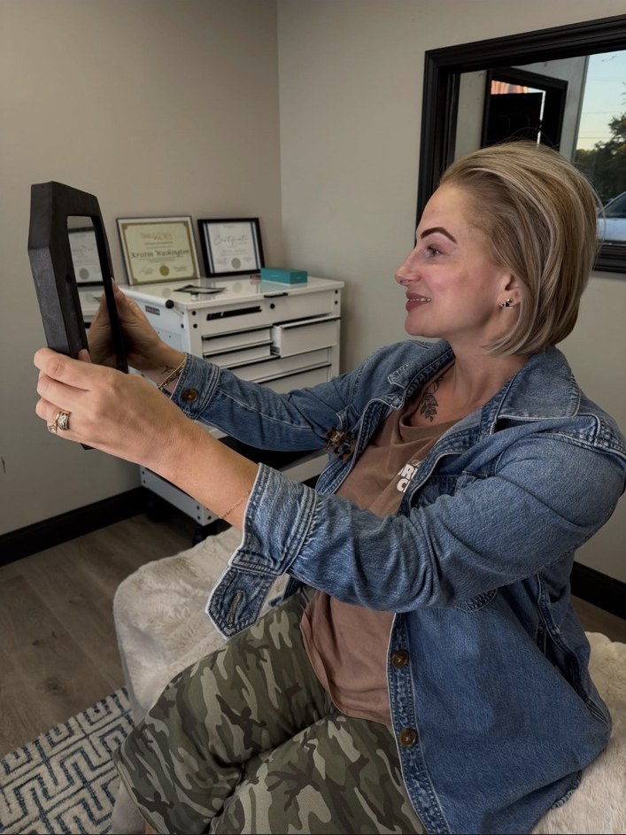 Beauty District powder ombré brow client viewing her results in a mirror